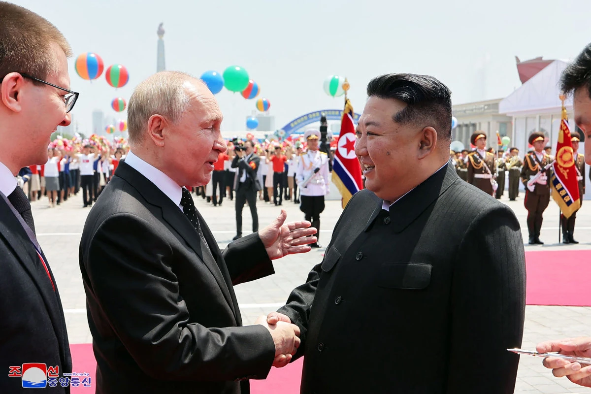 North Korea's leader Kim Jong Un (R) and Russia's President Vladimir Putin shake hands during a welcoming ceremony at Kim Il Sung Square in Pyongyang on June 19, 2024. KCNA VIA KNS/AFP)