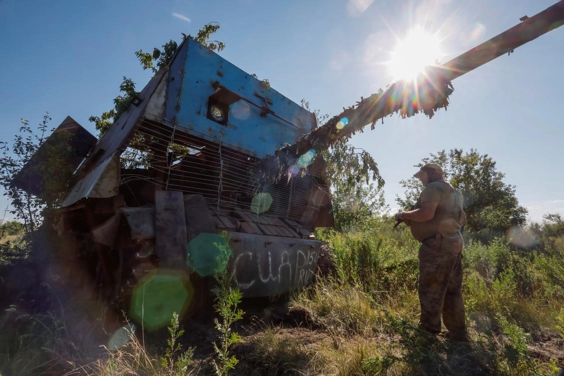 A Ukrainian serviceman of the 22nd Separate Mechanized Brigade stands next to a Russian T-62 Soviet main battle tank crafted with anti-drone protection that was recently captured by his unit at an undisclosed location in Donetsk region on Jun. 19, 2024. (Reuters)