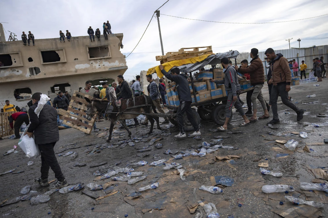 FILE — Palestinians loot a humanitarian aid truck as it crossed into the Gaza Strip in Rafah, Sunday, Dec. 17, 2023. A persistent breakdown in law and order is rendering an aid route in south Gaza unusable, the UN and NGOs say, days after Israel’s military said it would pause combat there to help aid reach desperate Palestinians. (AP)