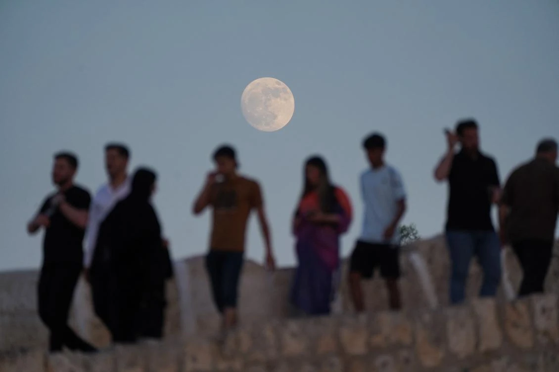 The full moon rises behind the Abbasid Bridge or know in Kurdish as Dalal Bridgein Kurdish, in the city of Zakho in Iraq’s northern autonomous Kurdistan region close to the Turkish border on June 20, 2024. (AFP)