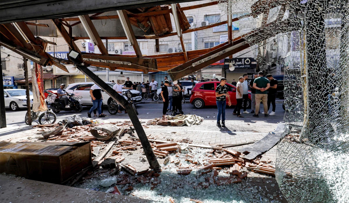 People gather at the site where two Palestinians were killed during an Israeli operation in Qalqilya in the occupied West Bank on June 21, 2024. (AFP)