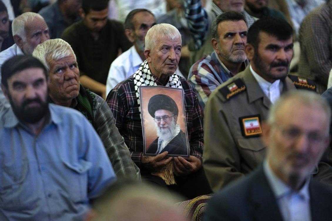 An Iranian worshipper holds a poster of the Supreme Leader Ayatollah Ali Khamenei in Friday prayer ceremony at the Imam Khomeini Grand Mosque a week before presidential election in Tehran. (AP)