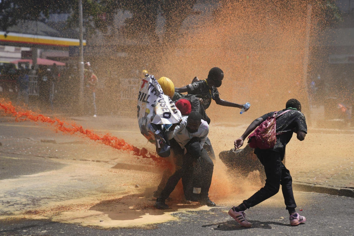 Protesters scatter as Kenya police spray water canon at them during a protest over proposed tax hikes in a finance bill in downtown Nairobi, Kenya Tuesday, June. 25, 2024. (AP)