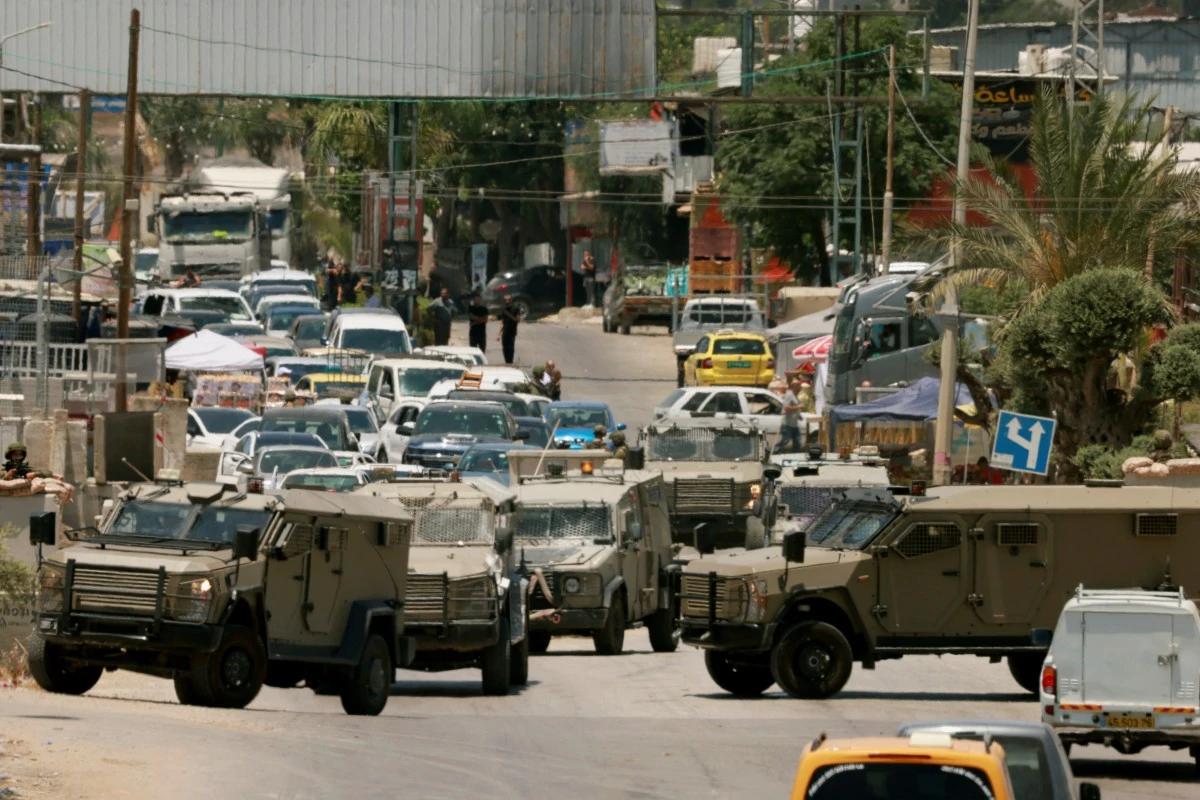 Traffic is blocked as Israeli army vehicles close off the entrance to the West Bank city of Qalqilya (AFP)
