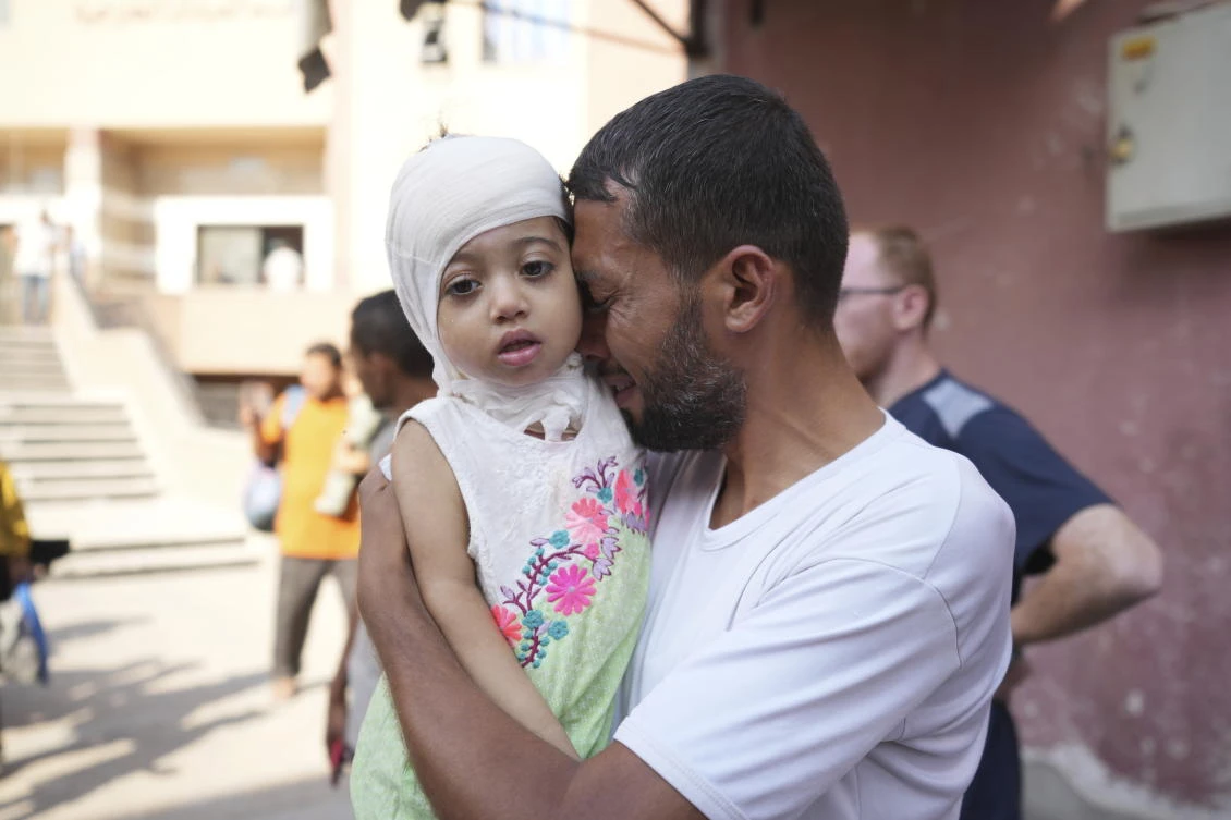A Palestinian man reacts as he says goodbye to his sick daughter before leaving the Gaza Strip to get treatment abroad through the Kerem Shalom crossing, in Khan Younis, southern Gaza Strip, Thursday, June 27, 2024. (AP)