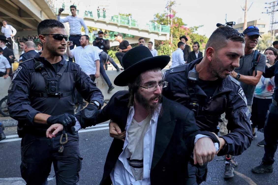 Police detain an ultra-Orthodox Jewish man during a protest against a Supreme Court order for ultra-Orthodox men to begin enlisting for military service, on June 27, 2024. (AFP)