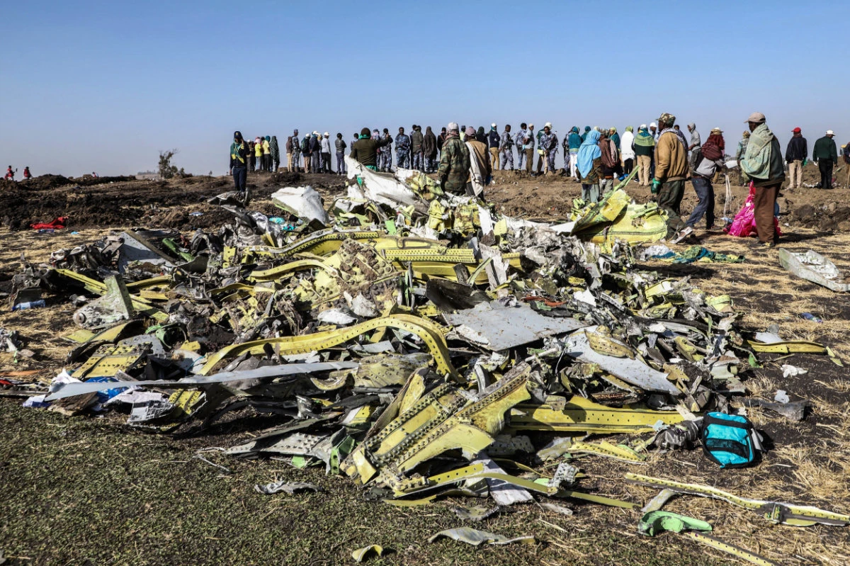 People stand near collected debris at the crash site of Ethiopia Airlines near Bishoftu, a town some 60 kilometes southeast of Addis Ababa, Ethiopia, on March 11, 2019. (AFP/File)