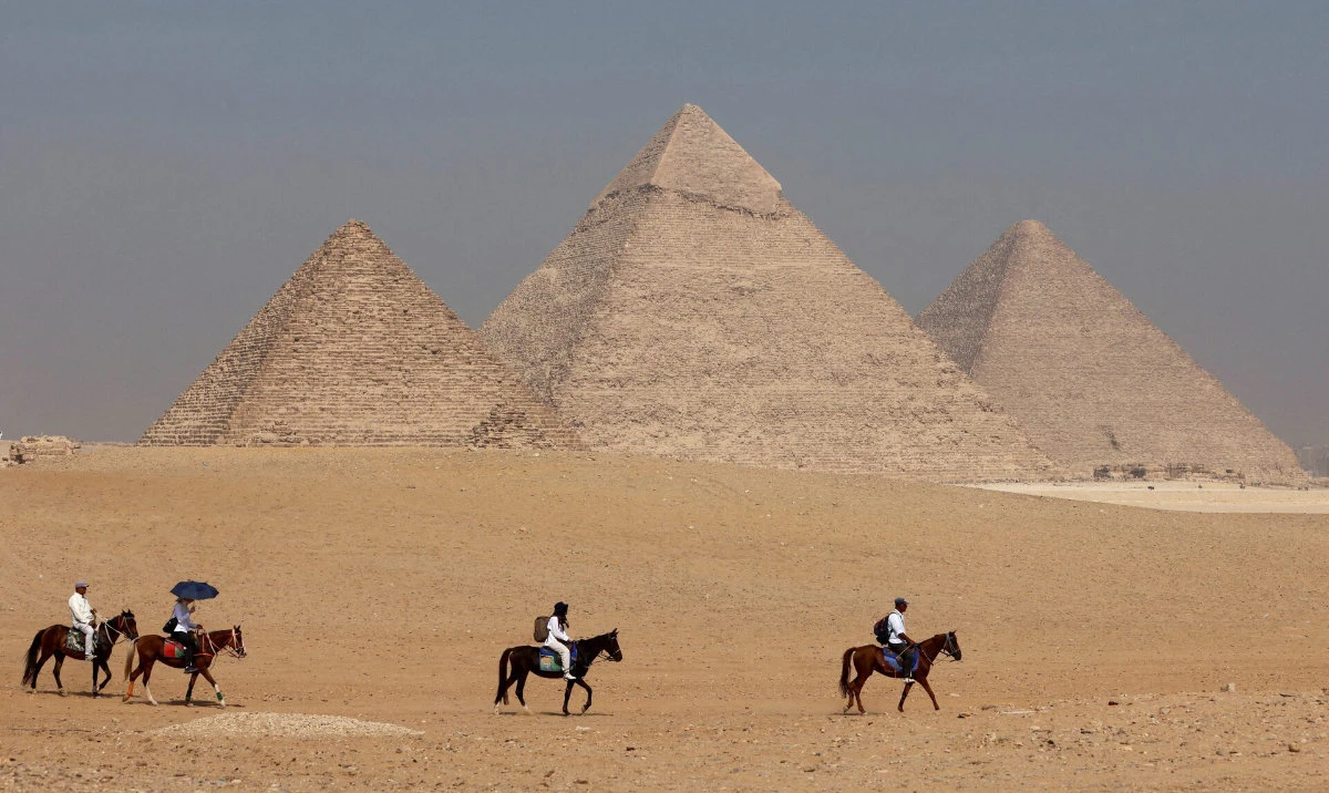 Tourists ride horses in front of the Great Pyramid of Giza, on the outskirts of Cairo, Egypt. (Reuters)