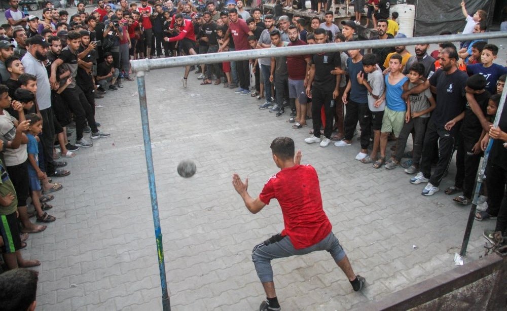 A displaced Palestinian takes a penalty during a football match at an UNRWA school, Jabalia, Gaza, July 23, 2024. (Reuters)
