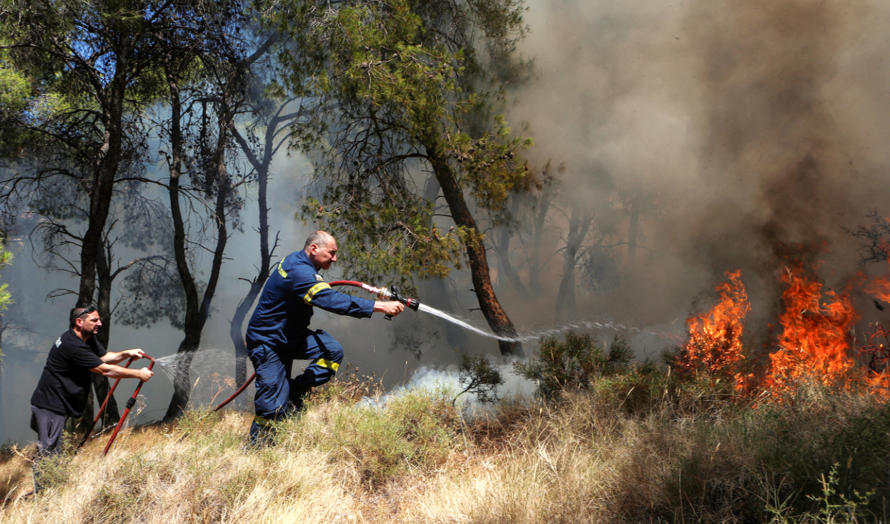 A firefighter works to extinguish a wildfire burning in Keratea, near Athens, Greece, Sunday. Greece has scaled up its preparations this year. (Reuters)