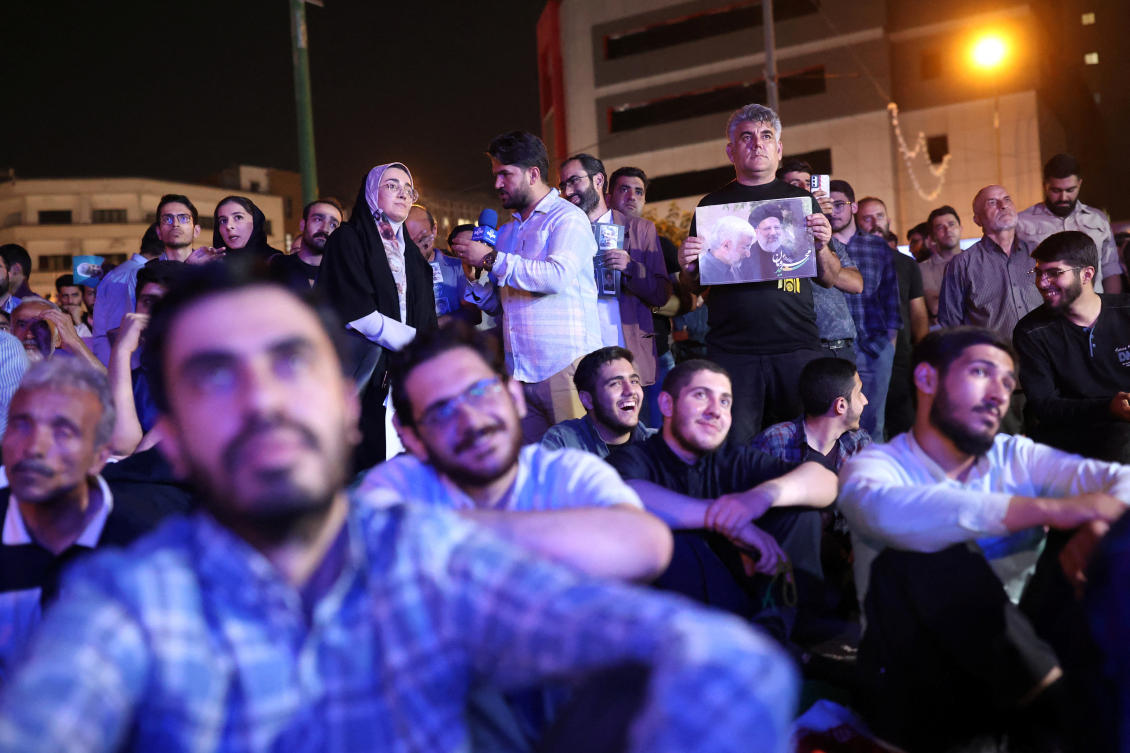 Above, people watch the debate of presidential candidates at a park in Tehran, Iran on July 1, 2024. (WANA via Reuters)