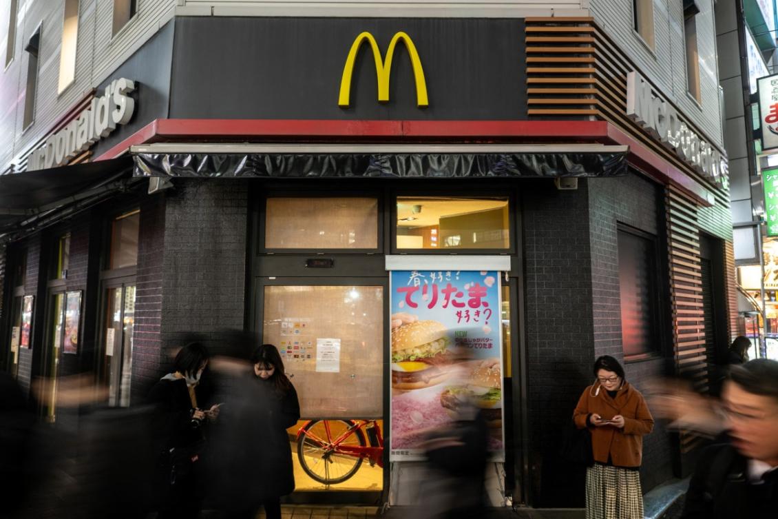 People stand in front of a temporary closed McDonald's in Shimbashi district of Tokyo on March 15, 2024. (AFP)