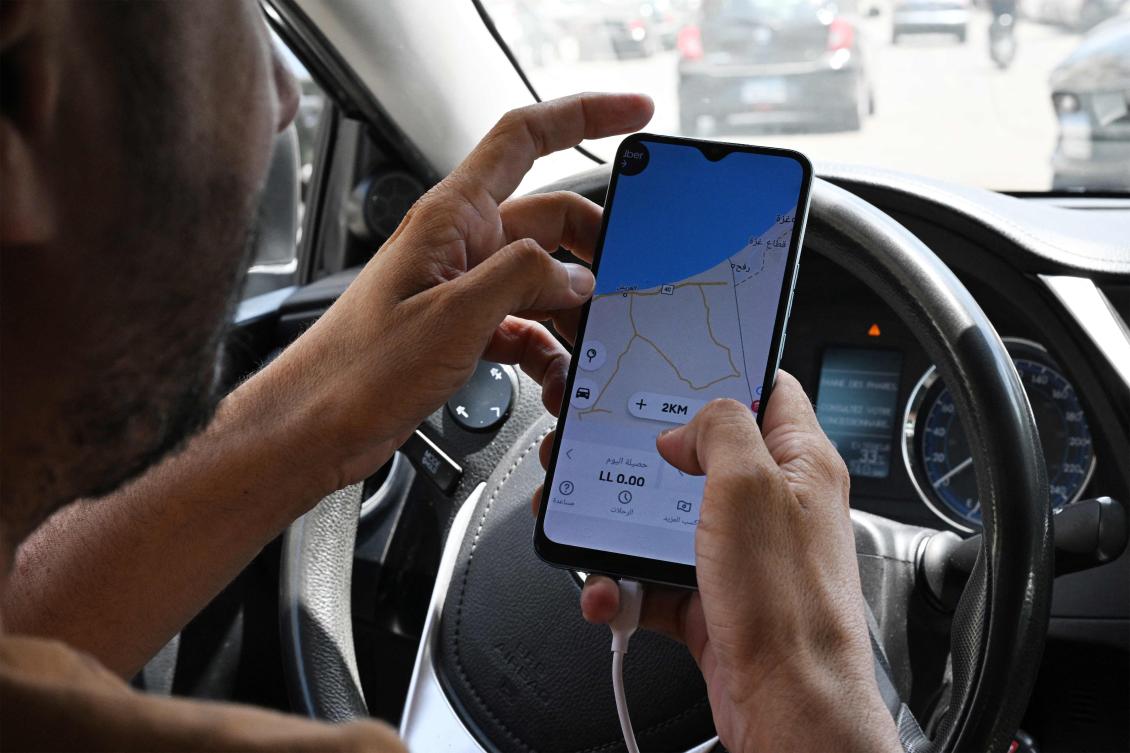 A driver shows his GPS jammed geolocation on the Uber application showing Gaza’s southern city of Rafah as he sits in his vehicle in Beirut’s Hamra street on June 11, 2024. (AFP)