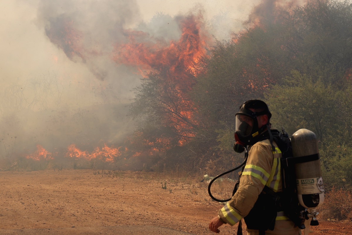 A firefighter deploys to extinguish a blaze after a drone fired from southern Lebanon was intercepted and landed near Kfar Dishon in the Upper Galilee in northern Israel. (File/AFP)