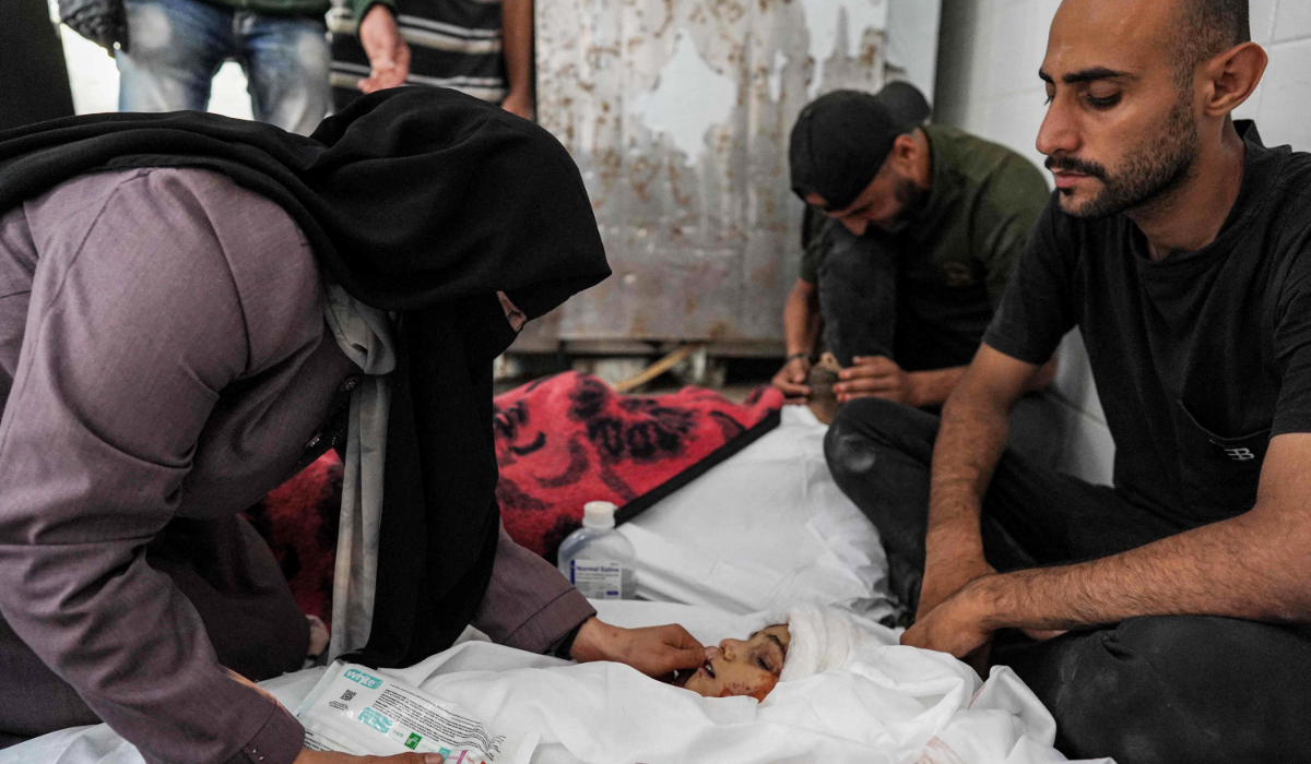 Family members mourn by the body of Islam Tayyim and his son Mohamed, who were killed during overnight Israeli bombardment on their house in Nuseirat in the central Gaza Strip, as they lie at the Aqsa Martyrs hospital in Deir el-Balah on July 2, 2024 amid the ongoing conflict in the Palestinian territory between Israel and Hamas. (AFP)