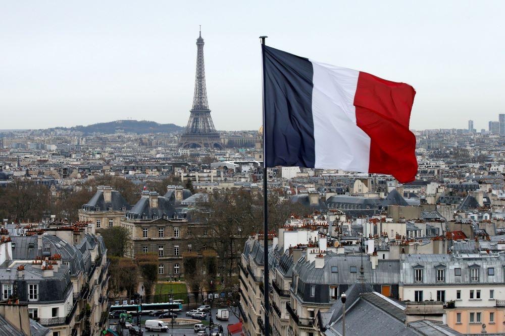 The French flag flies above the Paris skyline with the Eiffel Tower in the distance, Paris, France, March 30, 2016. (Reuters)