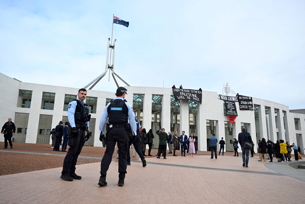 Pro-Palestinian protesters hang banners from the top of Parliament House in Canberra, Australia. (AAP/Reuters)