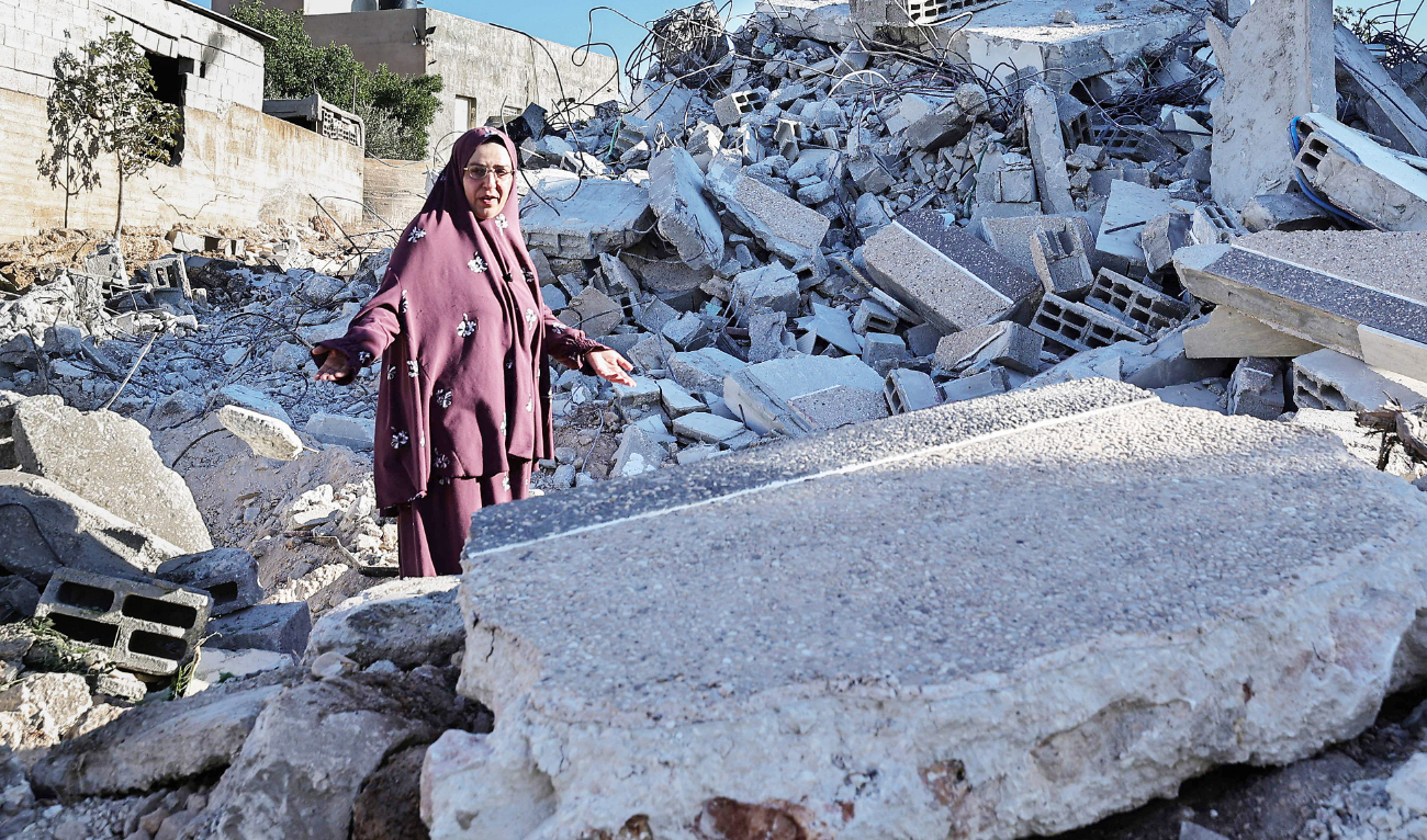 A woman walks on the rubble of her house in the occupied West Bank after it was demolished by the Israeli army. (AFP)