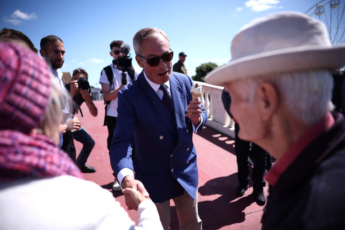Reform UK leader Nigel Farage meets residents as he eats a 99 Flake ice cream in Clacton-on-Sea, eastern England, on July 4, 2024 as Britain holds a general election. (AFP)
