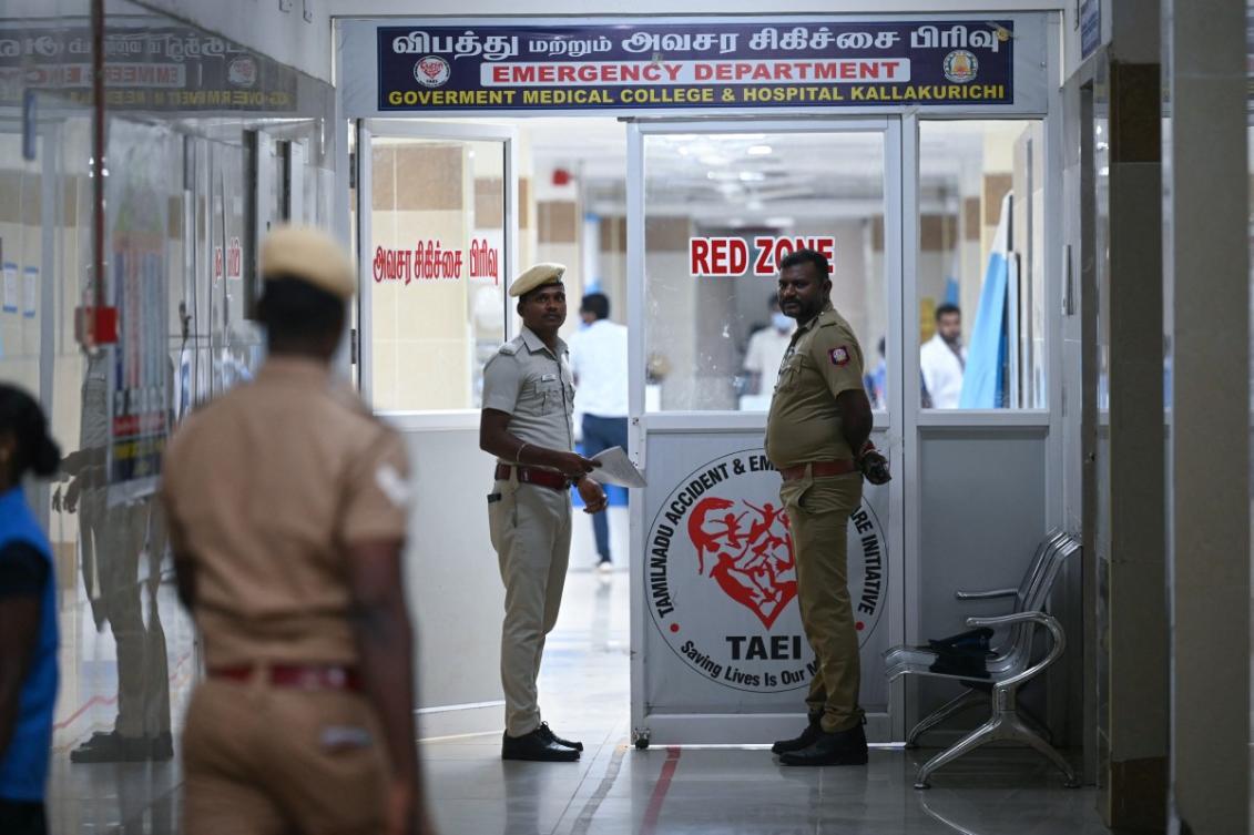 Police stand guard in front of a hospital ward where patients who consumed toxic illegal alcohol were admitted in Kallakurichi district of India's Tamil Nadu state on June 23, 2024. (AFP)