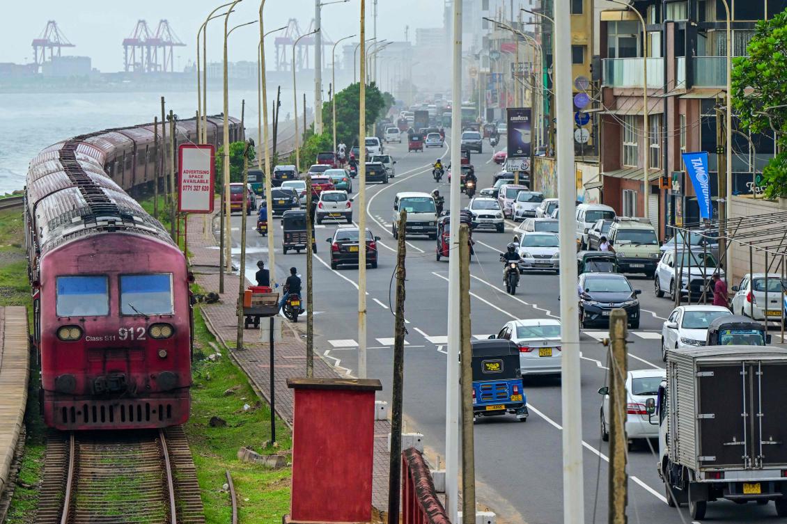 A train (L) arrives at a station in Colombo on July 4, 2024. (AFP)