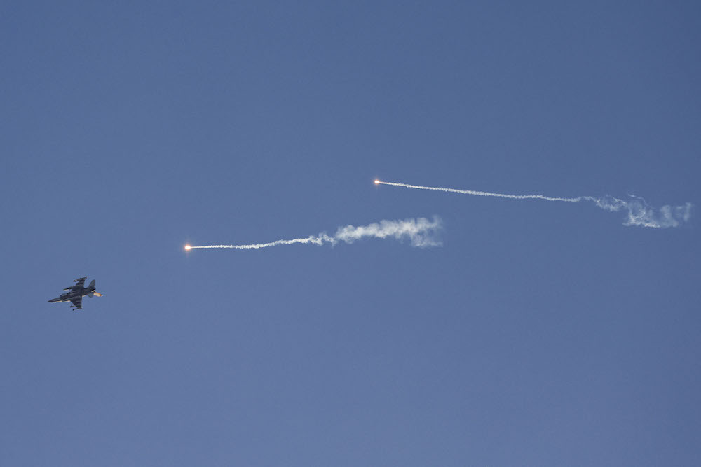 Above, an Israeli fighter jet fires flares as it flies to intercept a hostile craft launched over the border area with south Lebanon on July 7, 2024. (AFP)