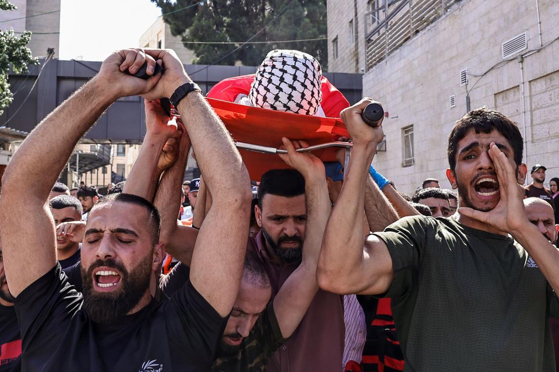 Mourners carry the body of Ghassan Ghareeb, who was killed during an Israeli raid in the occupied West Bank, during his funeral in Ramallah on July 9, 2024. (AFP)