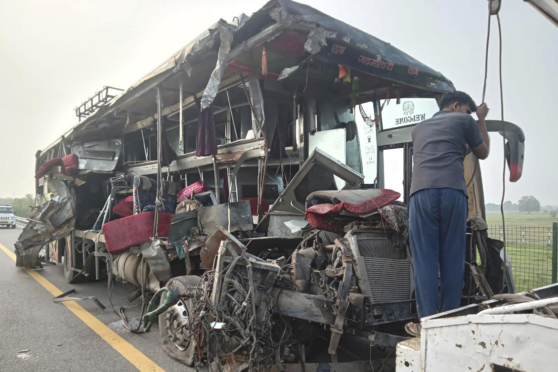 A roadside assistance worker tows away the mangled remains of a double-decker passenger bus that collided with a milk truck near Unnao, in northern India state of Uttar Pradesh on July 10, 2024. (AP)