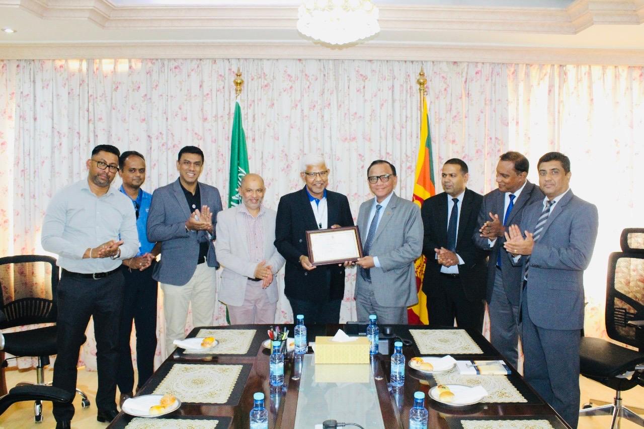 Sri Lankan Ambassador to Saudi Arabia Ameer Ajwad, center, hands a certificate of recognition to Chandralal Senadhira, a Sri Lankan expat who spent over 30 years of his career in the Kingdom. (Sri Lanka Embassy)