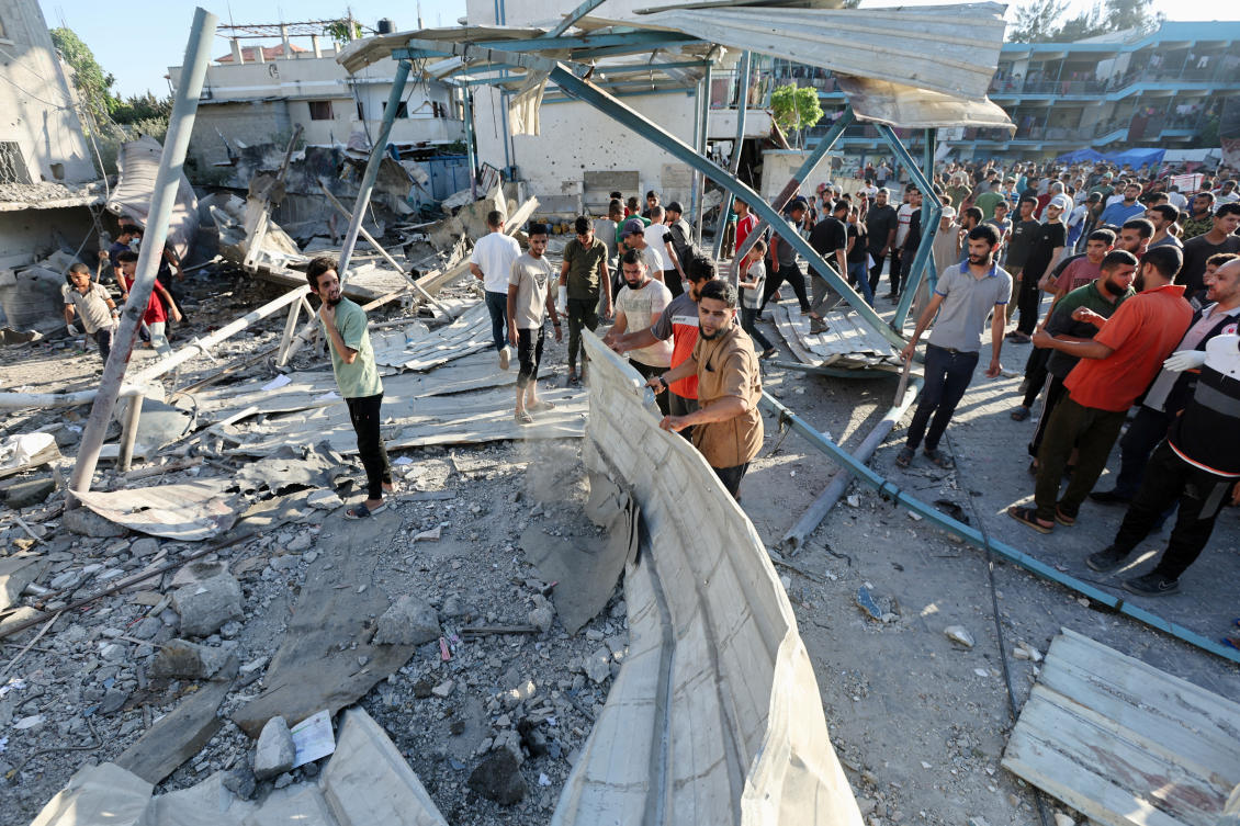 Palestinians look at the site of an Israeli airstrike on a UN school sheltering displaced people in Nuseirat camp in central Gaza Strip. (Reuters)