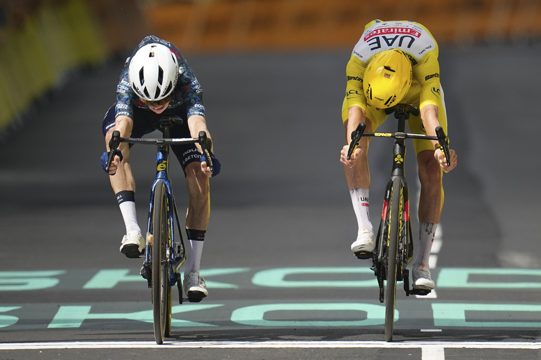Denmark's Jonas Vingegaard, left, pushes his wheel over the finish line to win ahead of Slovenia's Tadej Pogacar, wearing the overall leader's yellow jersey, during the 11th stage of the Tour de France cycling race Wednesday. (AP)