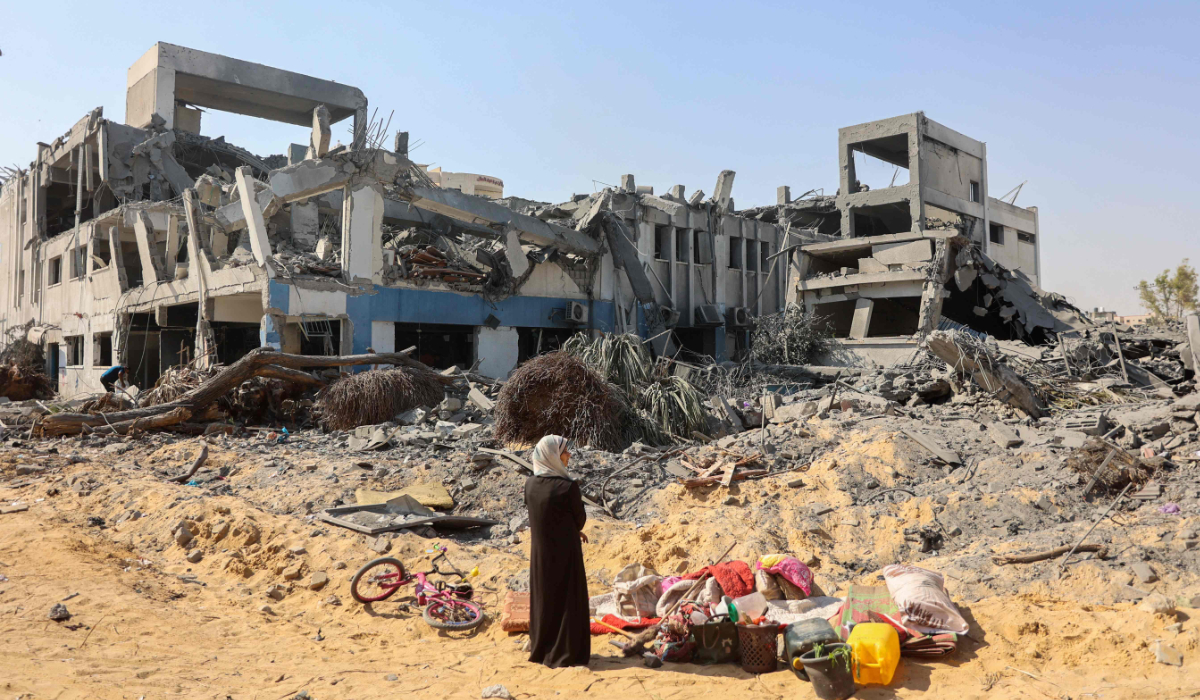 A woman looks around as she salvages items at the damaged UN Relief and Works Agency for Palestine Refugees (UNRWA) building complex in western Gaza City's Al-Sinaa neighbouhood on July 12, 2024, following the withdrawal of Israeli troops from the area amid the ongoing conflict between Israel and the militant Hamas group in the besieged Palestinian territory. (AFP)
