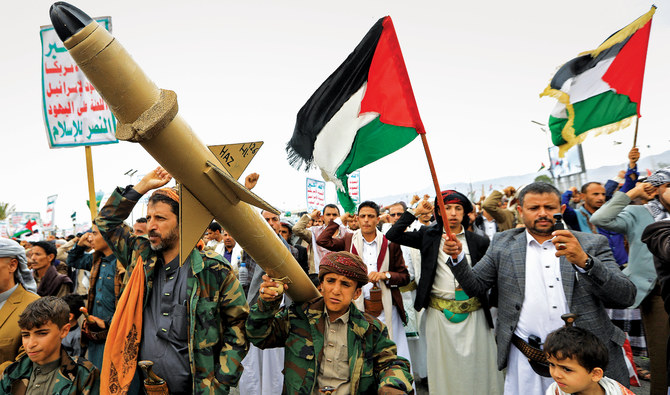 Yemenis wave Palestinian flags and hold mock rockets during a march in the Houthi-run capital Sanaa in solidarity with the people of Gaza. (AFP/File Photo)