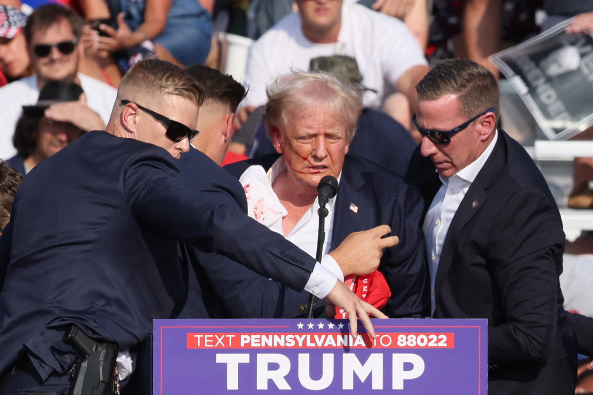 Republican presidential candidate and former US. President Donald Trump is assisted by security personnel after gunfire rang out during a campaign rally at the Butler Farm Show in Butler, Pennsylvania, on July 13, 2024. (REUTERS)