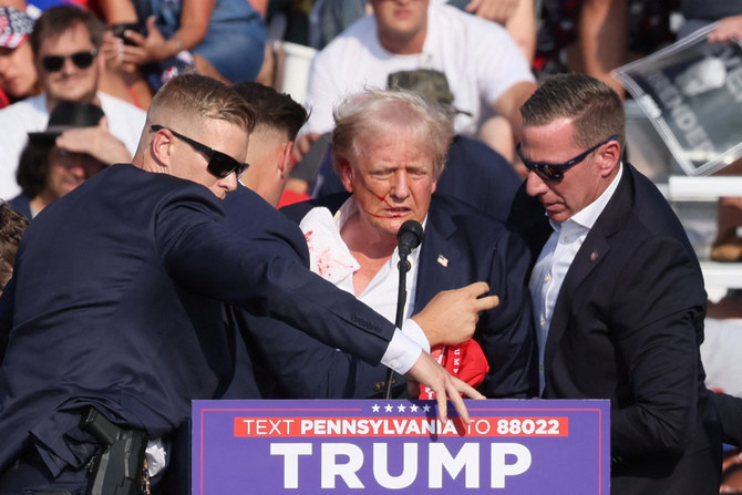 Republican presidential candidate and former US. President Donald Trump is assisted by security personnel after gunfire rang out during a campaign rally at the Butler Farm Show in Butler, Pennsylvania, on July 13, 2024. (REUTERS)