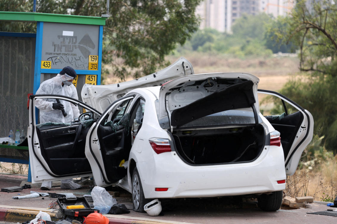 A person inspects a damaged vehicle at the scene of a suspected attack near a junction in Nir Tzvi, Israel, July 14, 2024. (Reuters)
