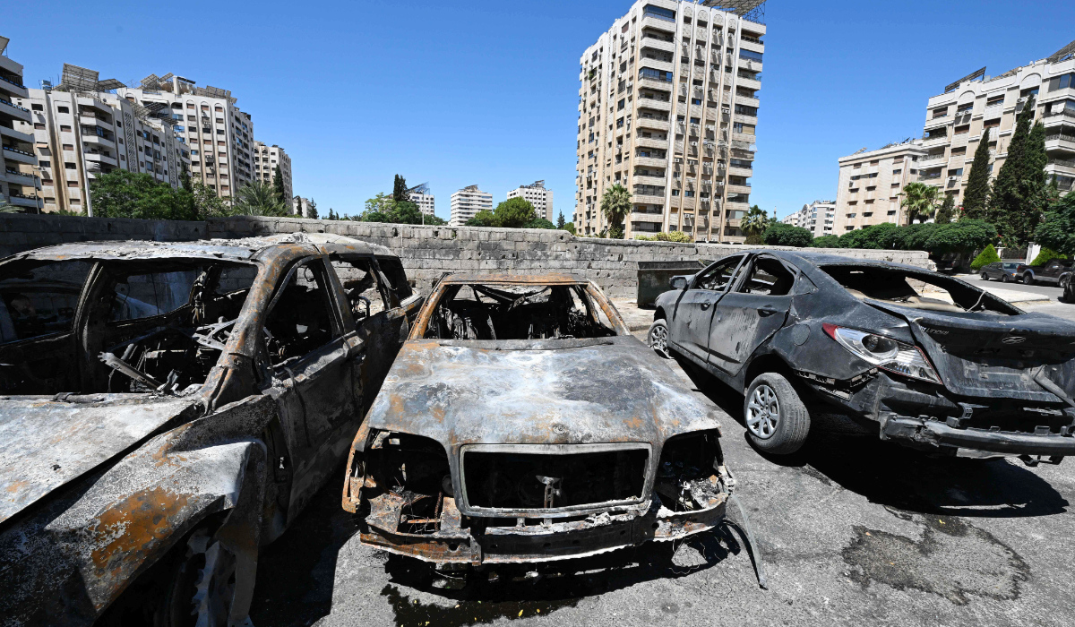 Charred vehicles litter a parking area in the aftermath of Sunday’s Israeli strike in the neighborhood of Kafr Sousse in Damascus. (AFP)