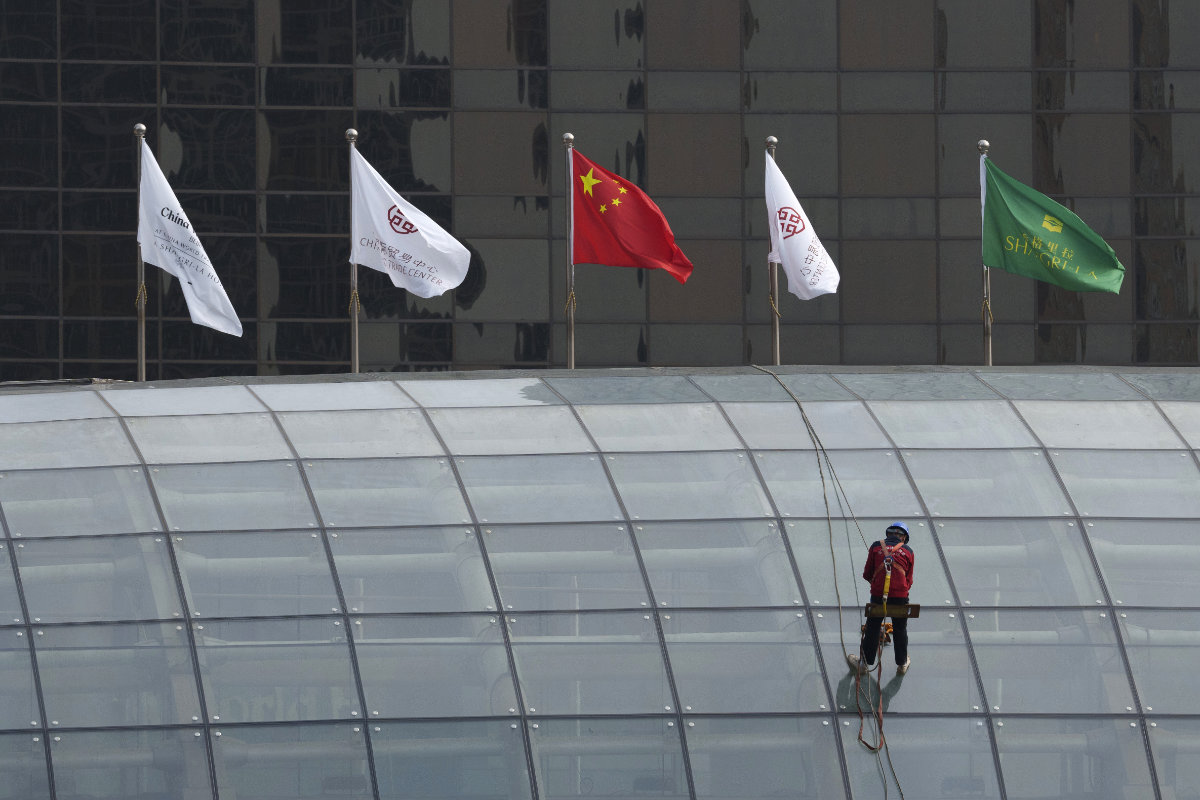 A worker descends on the rooftop of a building at the central business district in Beijing, China on July 15, 2024. China's ruling Communist Party is starting a four-day meeting Monday that is expected to lay out a strategy for self-sufficient economic growth. (AP)