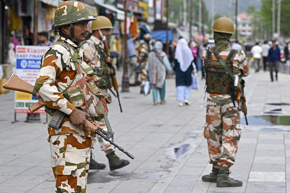 Indian security personnel stand guard at a market in Srinagar on May 10, 2024. India and Pakistan both claim Kashmir in full and have fought three wars for control of the Himalayan region. (AFP)