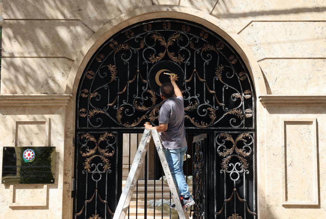 An Iranian worker paints Azerbaijan’s sign on the entrance gate to the new Azeri embassy in Tehran, Iran, 15 July 2024. (EPA)