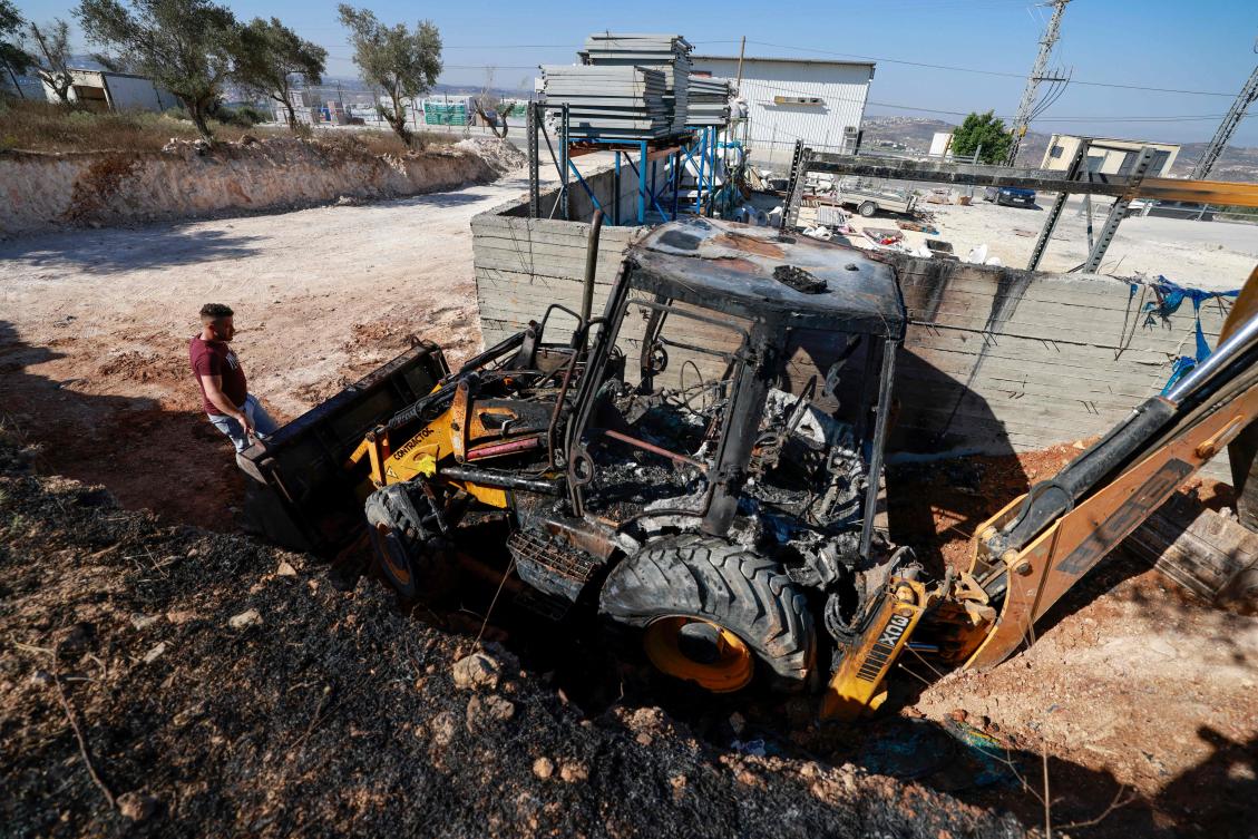 Muhammad Salem from Bazariya village in the occupied West Bank inspects the damage at his construction material depot including a burnt bulldozer after a reported overnight attack by Israeli settlers from the Homesh settelment on July 12, 2024. (AFP)