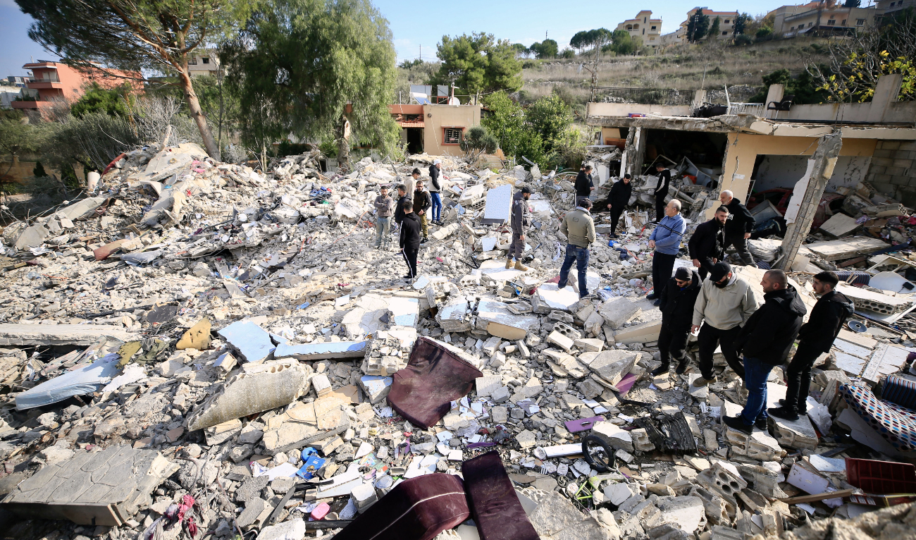 People check the rubble of a building in Bint Jbeil in southern Lebanon near the border with Israel, following Israeli bombardment the previous night, on December 27, 2023. (AFP/File)