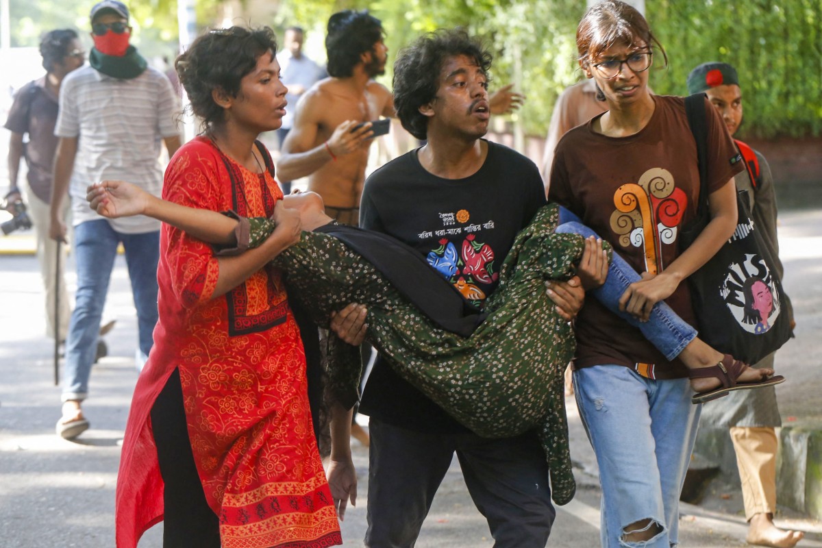 Bangladeshi students carry a wounded woman after clashes with the youth wing of the ruling Awami League in Dhaka on July 15, 2024. (AFP)
