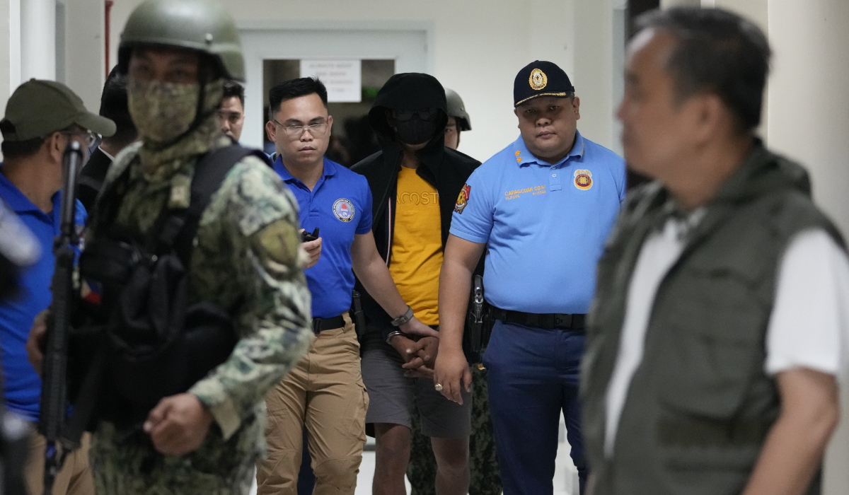 A suspect in the killing of two Australian nationals and a Filipino is escorted under tight security following his surrender in Tagaytay City, Cavite on July 17, 2024. (AP)