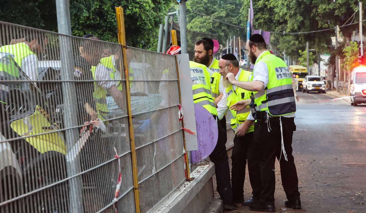 Team members from the ZAKA Search & Rescue transfer the body of a person who died in an explosion in Tel Aviv to an ambulance on July 19, 2024. An explosion at a building in Tel Aviv early on July 19 left one person dead and two lightly injured, an Israeli emergency services spokesperson told AFP. (AFP)