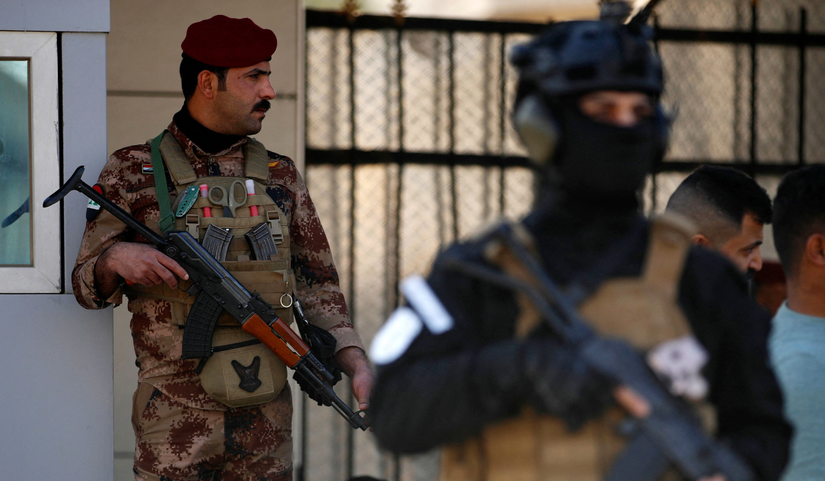 A paramilitary of the Hashed al-shaabi (Popular Mobilisation) forces stands guard during the funeral of a comrade, who died in American air strikes targeting Iran-backed groups the day before, at the Hashed al-shaabi forces' headquarters in Baghdad on January 25, 2024. (AFP)