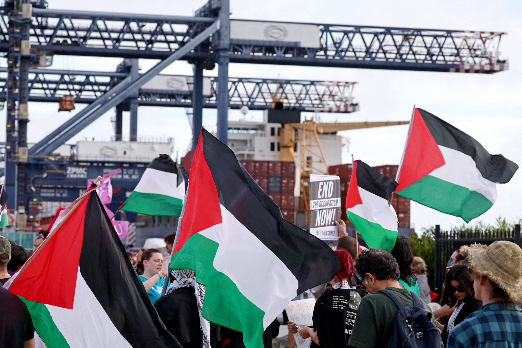 This photo taken on November 21, 2023 shows members of the Australian Palestinian community holding flags and placards during a protest at the Port Botany terminal in Sydney. (AFP)