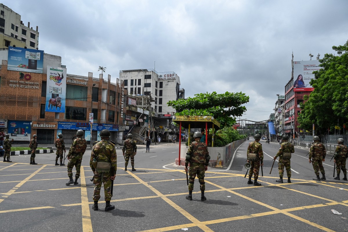 Bangladesh soldiers stand guard along the road following a curfew and the deployment of military forces in Dhaka on July 20, 2024, after days of clashes during protests against government job quotas. (AFP)