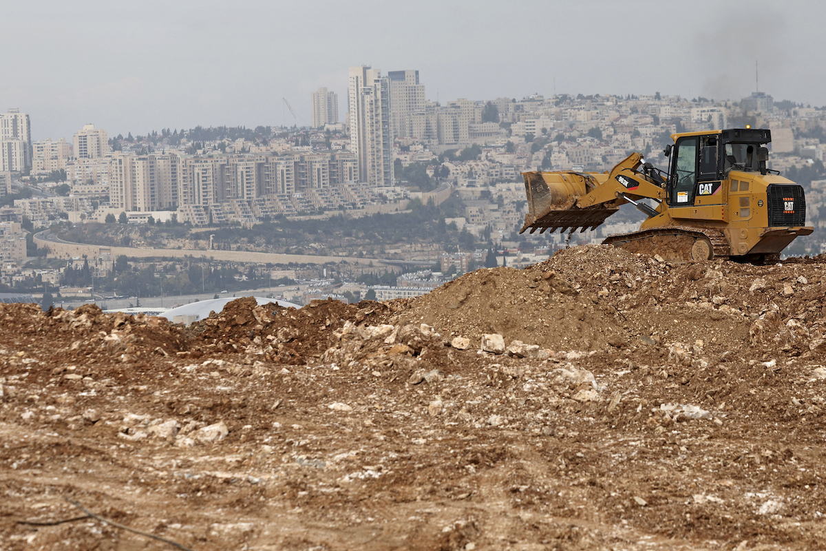 A bulldozer operates at a construction site in Givat HaMatos, an Israeli settlement suburb of annexed east Jerusalem on December 7, 2023. (File/AFP)