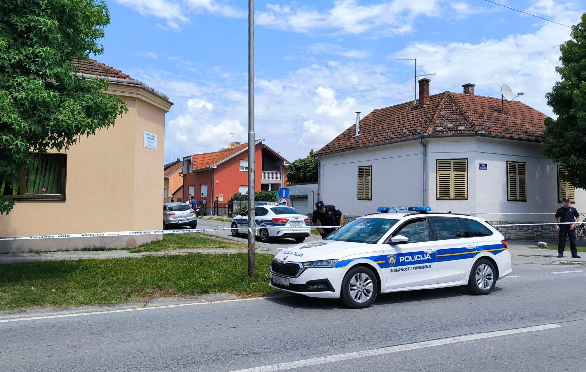 Croatian police officers stand guard in front of a retirement home, left, where at least five people were killed in a shooting in Daruvar on July 22, 2024. (AFP)